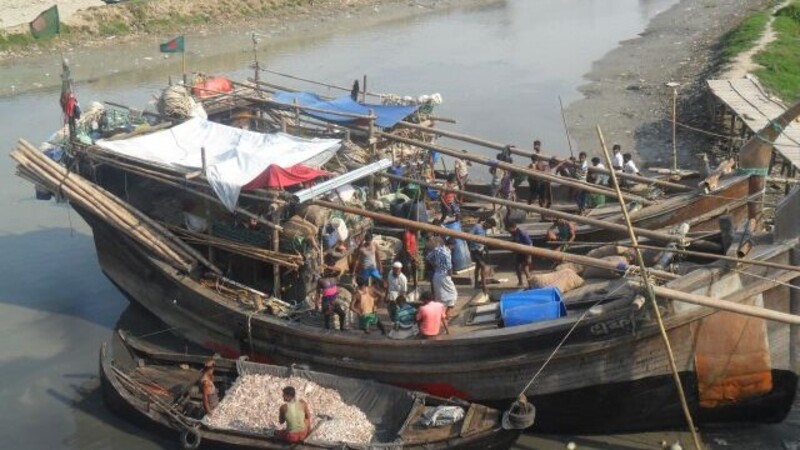 Arbeitende Menschen auf einem Fischerboot in Bangladesch.